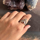 Boho-inspired silver ring featuring garnet and crown detailing
