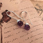 Stylish hook 925 sterling silver earrings featuring round cut amethyst gemstones.