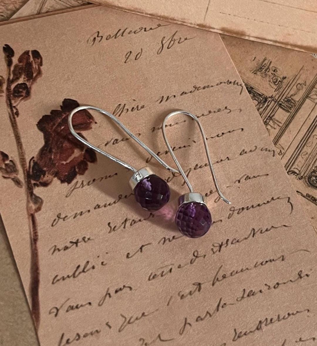 Charming round cut amethyst earrings on 925 sterling silver hooks.