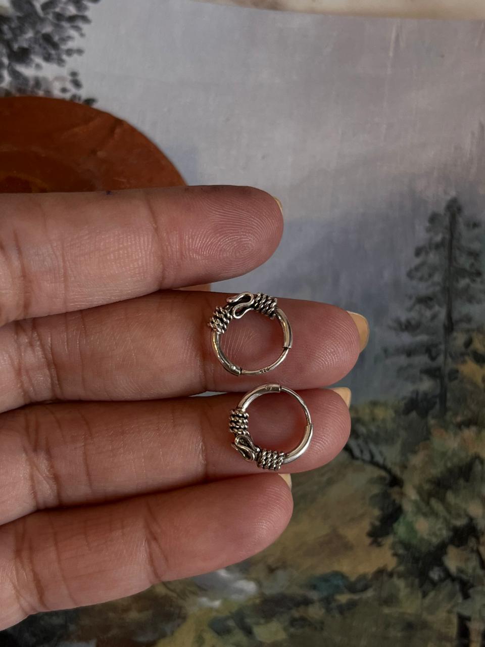 Vintage-inspired silver hoops featuring detailed design 3.