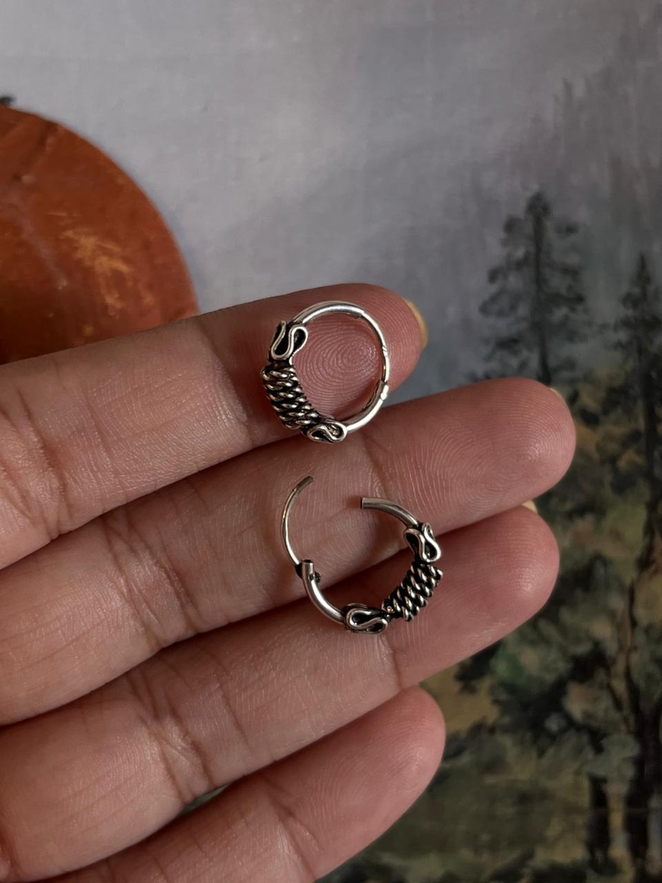 Vintage-inspired silver hoops featuring a detailed design 4.