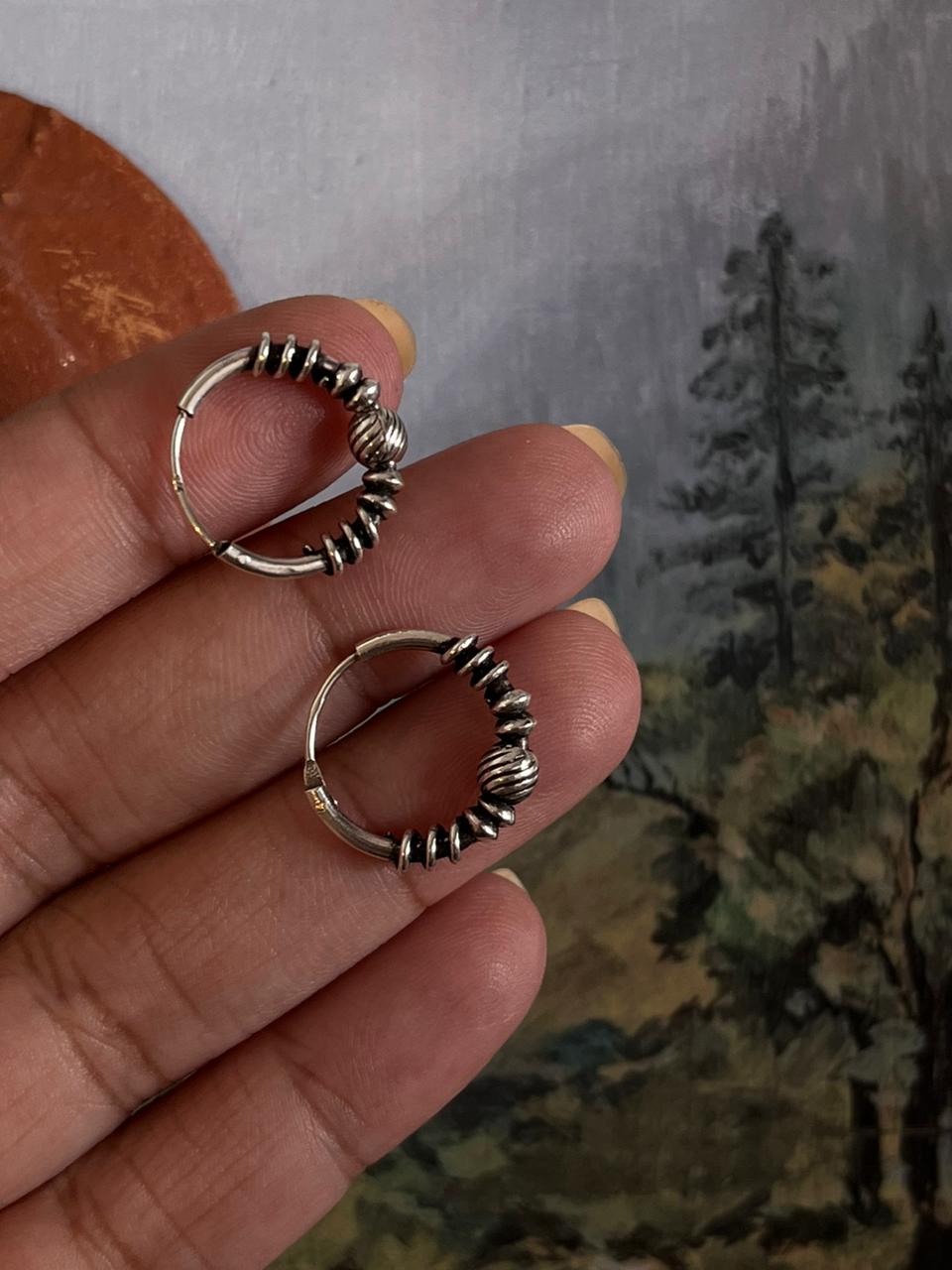 Vintage-style silver hoops featuring detailed design 5.