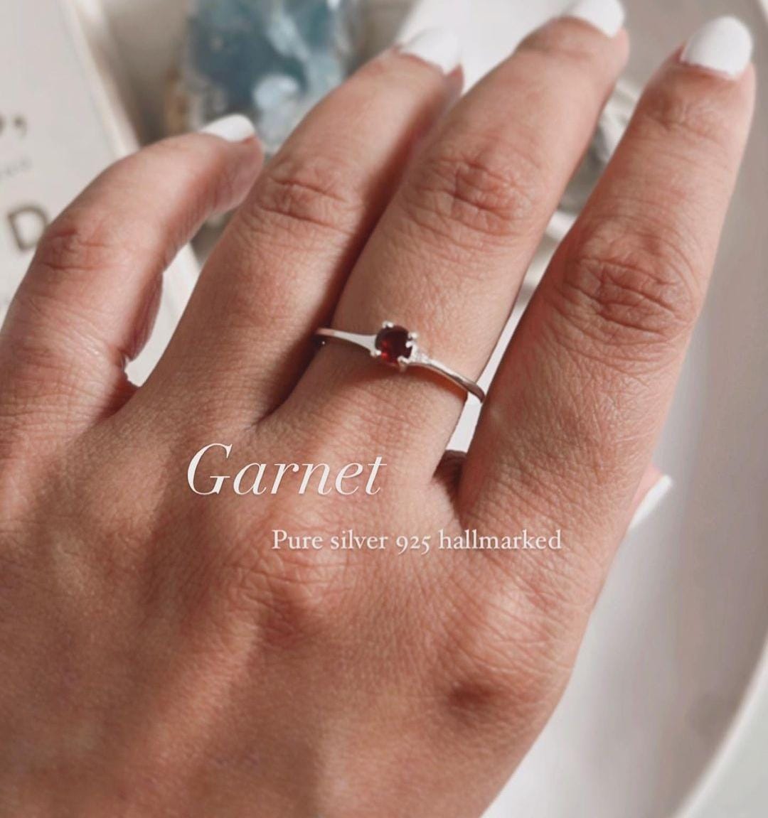 Classic silver ring featuring a single garnet gemstone