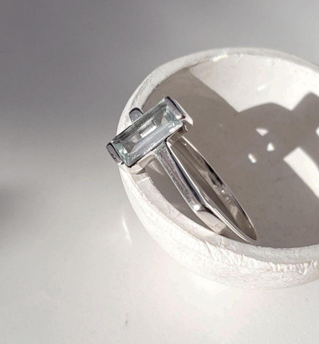 Stylish Blue Topaz Side Stone Ring in Silver