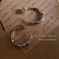 Close-up of crescent moon face design on CZ studded silver 925 half hoop earrings