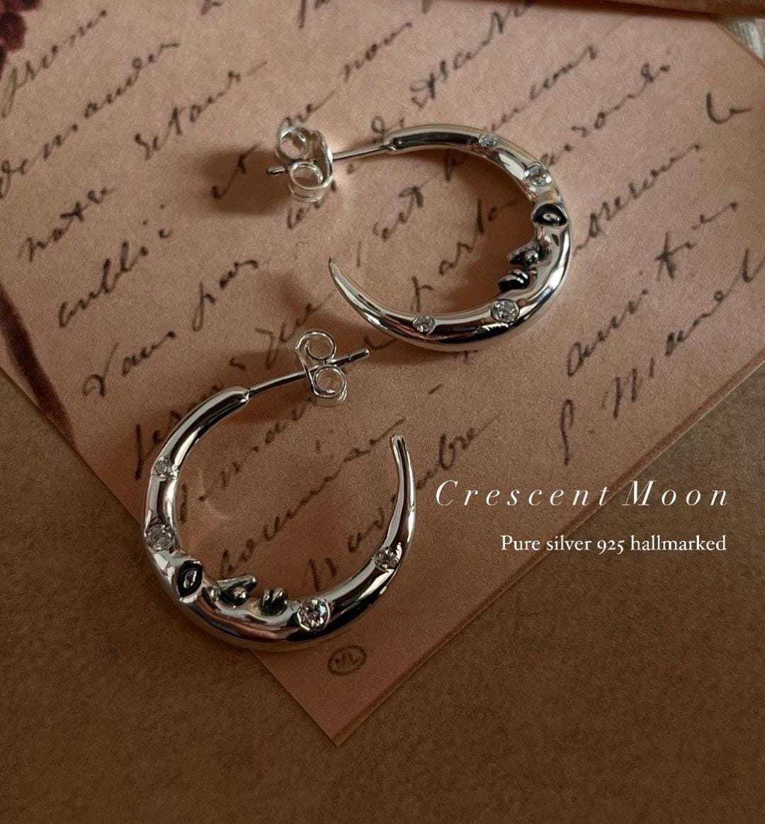 Close-up of crescent moon face design on CZ studded silver 925 half hoop earrings