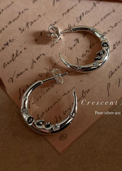 Close-up of crescent moon face design on CZ studded 925 sterling silver half hoop earrings