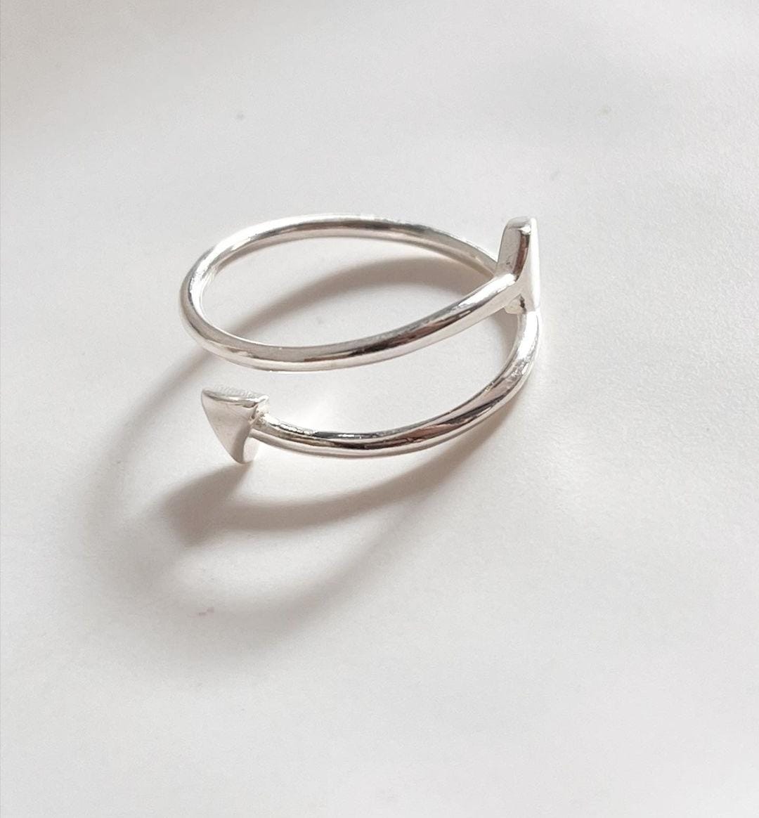 Sleek adjustable silver ring with a bold arrow design.