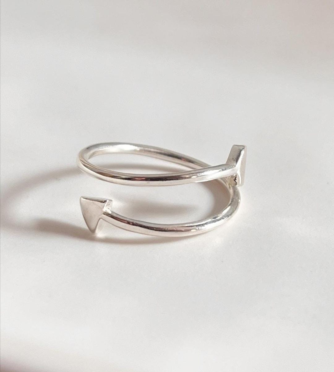 Minimalist adjustable silver ring featuring a sleek arrow motif.