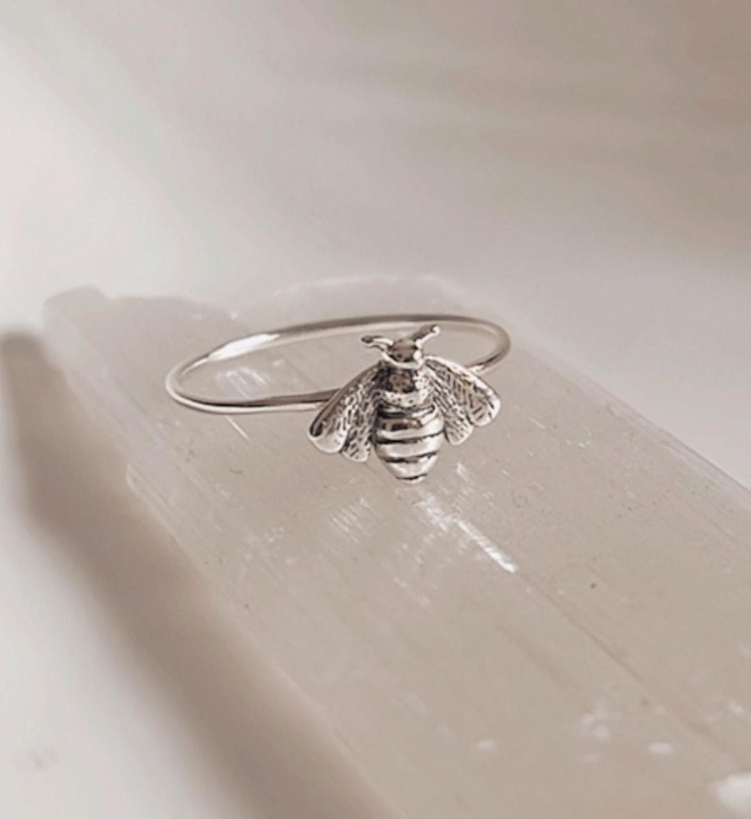 Sleek and bold silver ring with a large bee motif.