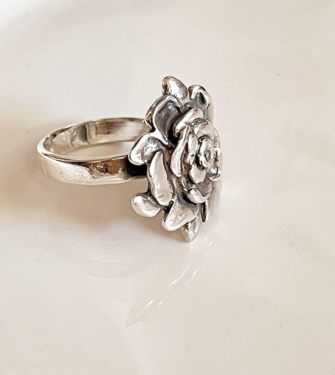 Bold silver ring with a chunky band and rose detailing