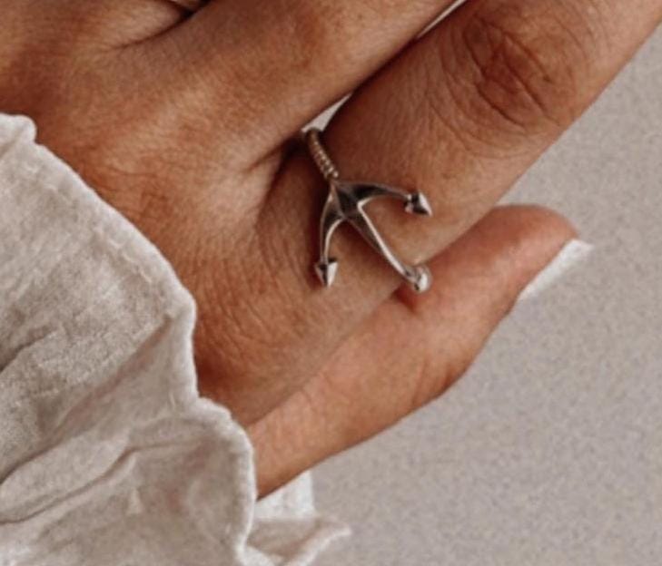 Nautical-inspired silver ring with an anchor emblem.