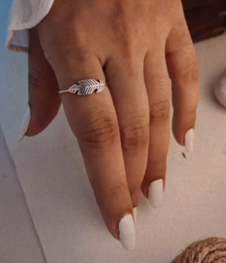 Handcrafted silver ring featuring a small feather