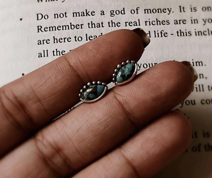 Close-up of evil eye copper turquoise silver studs with detailed design