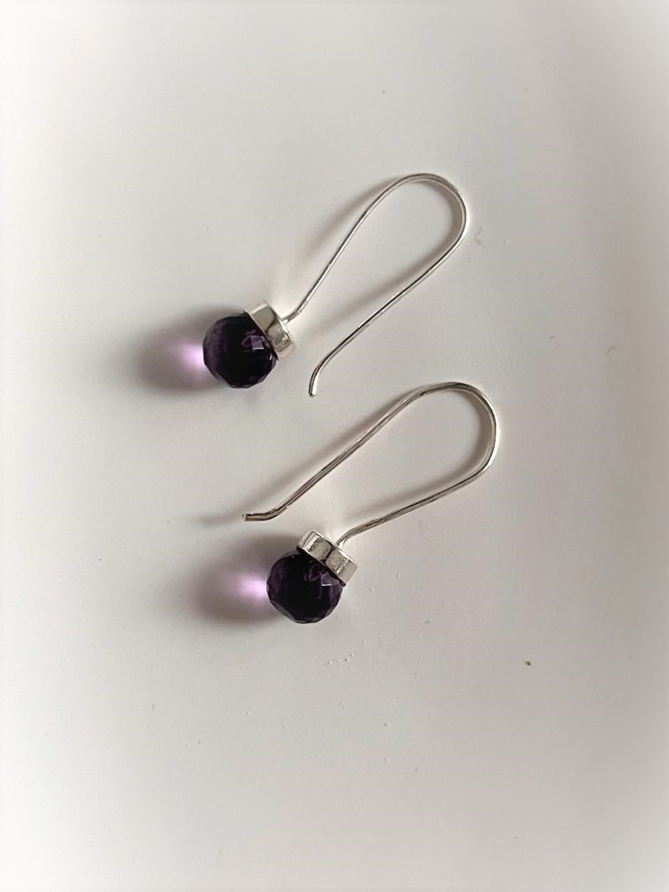 Delicate 925 Sterling Silver hook earrings with round cut amethyst gemstones.