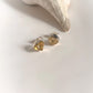 Close-up of raw uncut citrine stones set in silver stud earrings