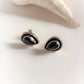 Chic black onyx pear-shaped studs in sterling silver for a unique look.
