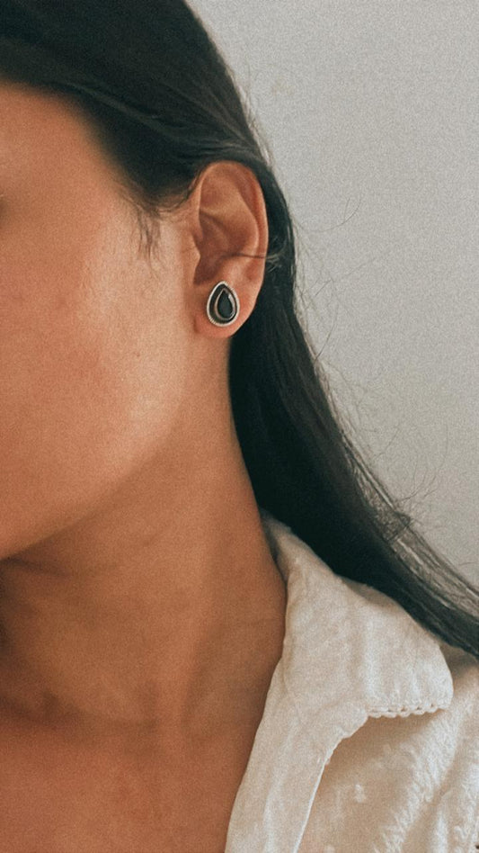 Boho-inspired black onyx pear silver studs with intricate design.