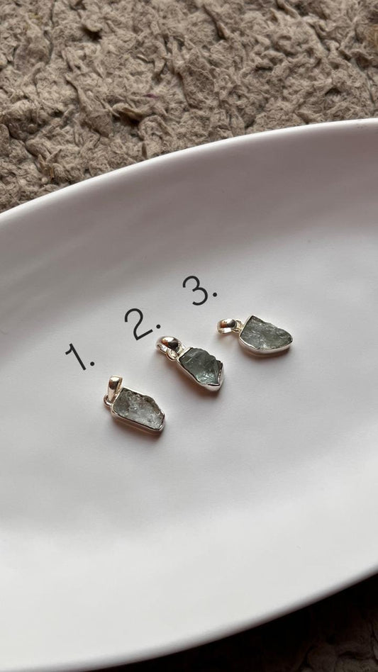 Raw uncut aquamarine gemstone pendant set in sterling silver.