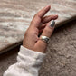 Close-up view of silver ring with three rolling interlinked bands