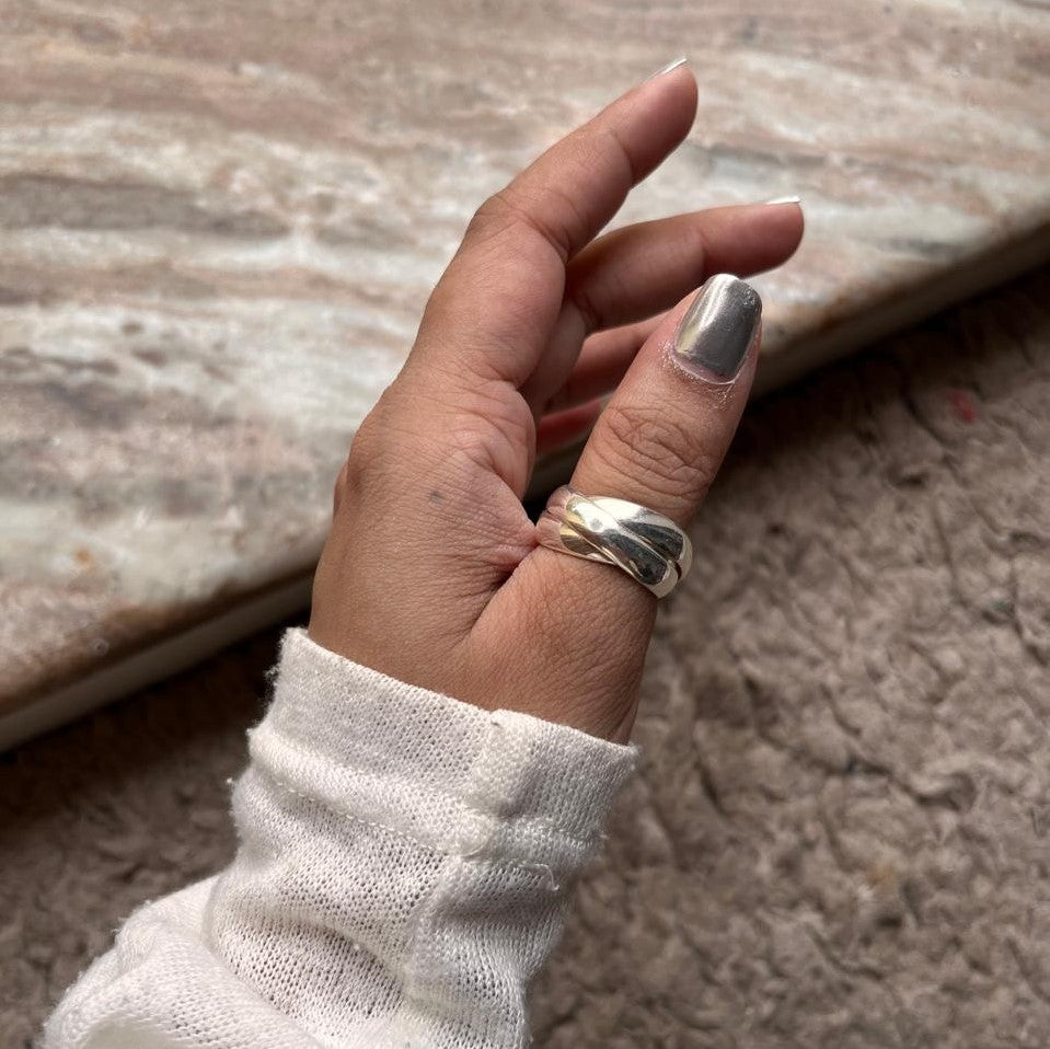 Close-up view of silver ring with three rolling interlinked bands