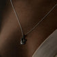 Close-up of a sleek silver cat-shaped pendant on a necklace