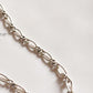 Close-up of Figaro neck silver chain with smooth, elongated links