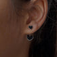 Sleek black heart enamel silver studs with modern design.