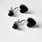 Bold silver studs with black heart enamel for a fashionable look.