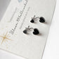 Elegant black heart enamel silver studs with sleek design.
