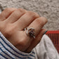Adjustable silver ring featuring a garnet moon design