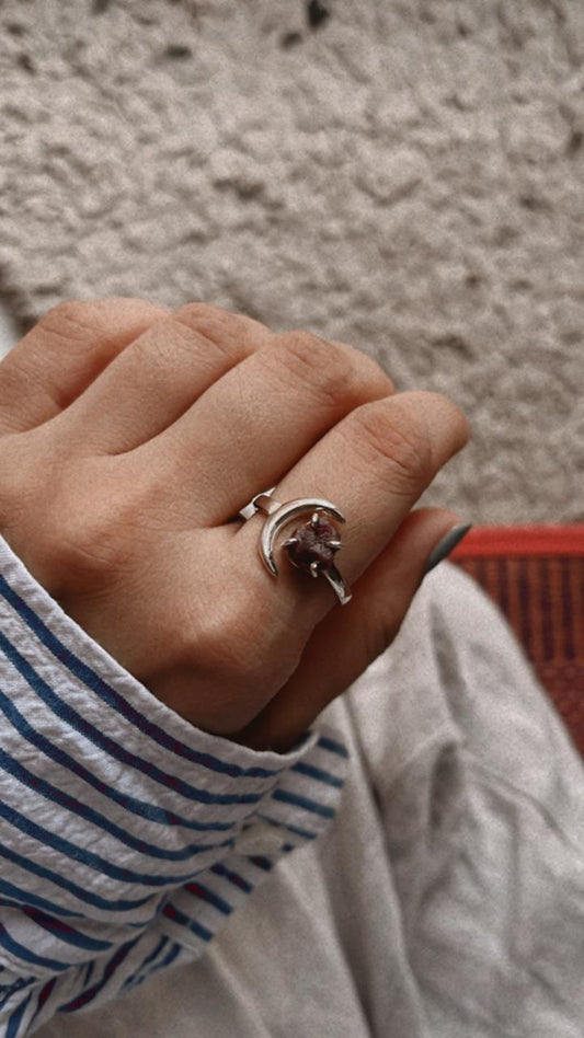 Adjustable silver ring featuring a garnet moon design