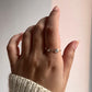 Minimalist silver band ring with arrow-inspired design.