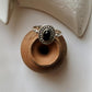 Black Onyx Rawa Tribal Silver Ring displayed on a clay pot, featuring a unique silver design and deep black stone.