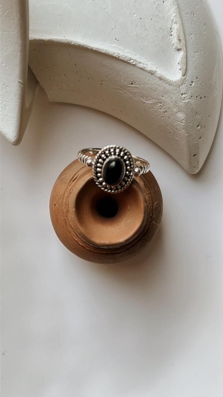 Black Onyx Rawa Tribal Silver Ring displayed on a clay pot, featuring a unique silver design and deep black stone.