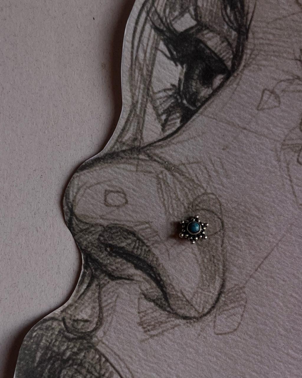 Tribal-inspired silver nose pin featuring turquoise stone and wired back design