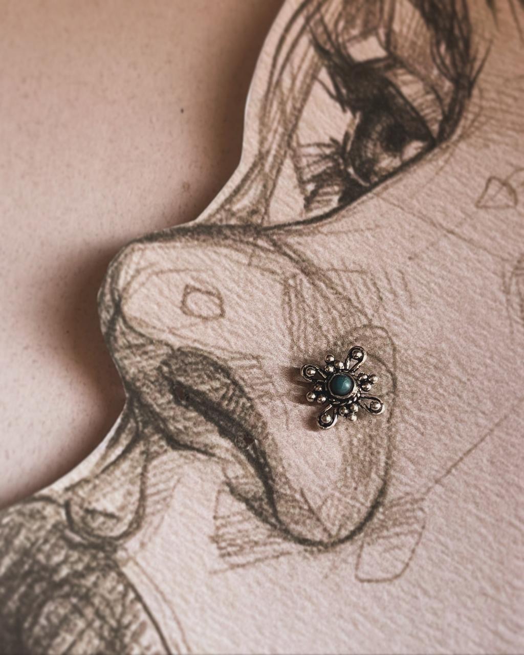 Tribal-inspired silver nose pin featuring turquoise gemstone and wired back