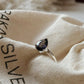 Close-up of Iolite Solitaire Pear Silver Ring on a white background