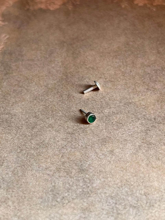 Close-up of Green CZ Screw Back Minimal Silver Nose Pin