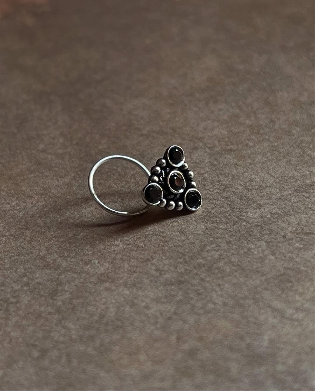 Tribal-style silver nose pin featuring black CZ stone and wired back
