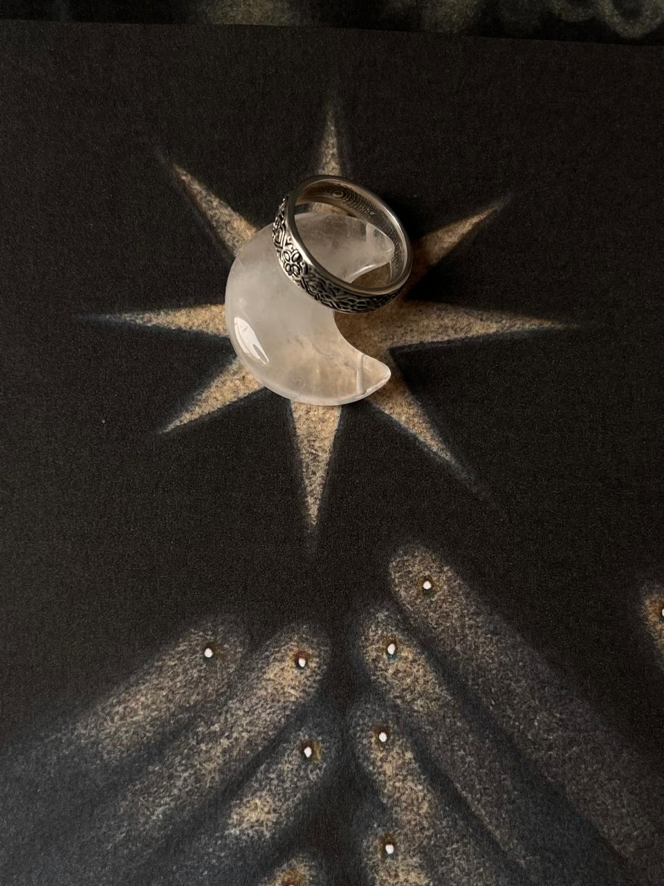 925 silver ring displayed on a dark background with a star and hands, symbolizing unique and thoughtful gift ideas.