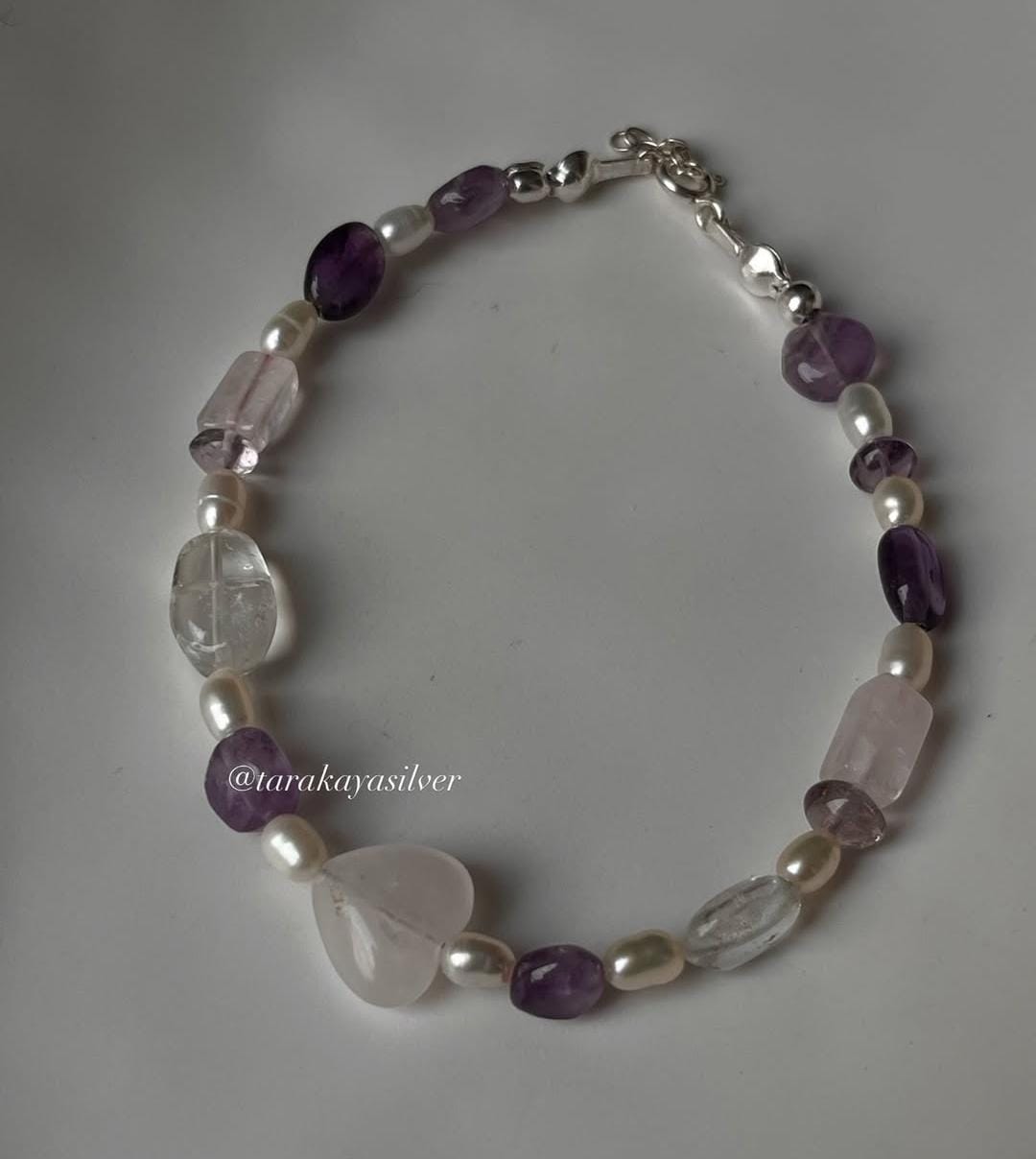 Handcrafted silver bracelet featuring rose quartz heart charm