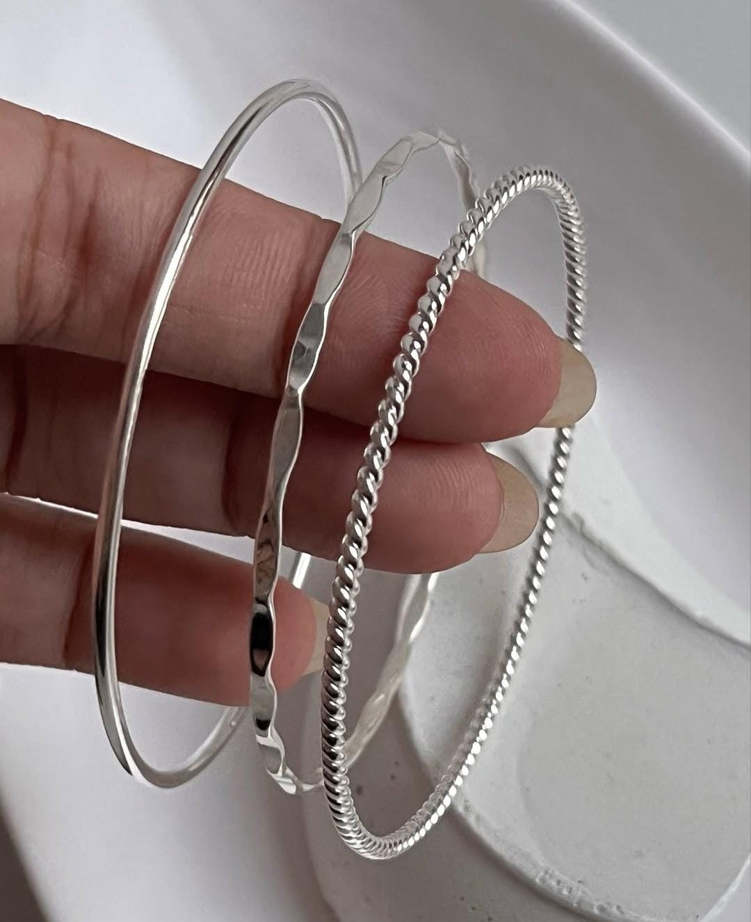 Hammered, rope, and smooth finish silver bangles in stack set