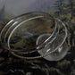 Boho silver bangle stack with hammered, rope, and plain styles  