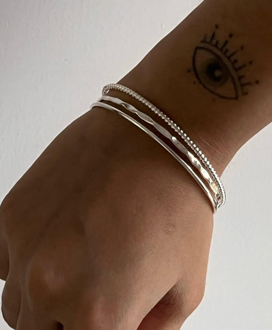 Textured hammered, rope, and plain silver bangle stack