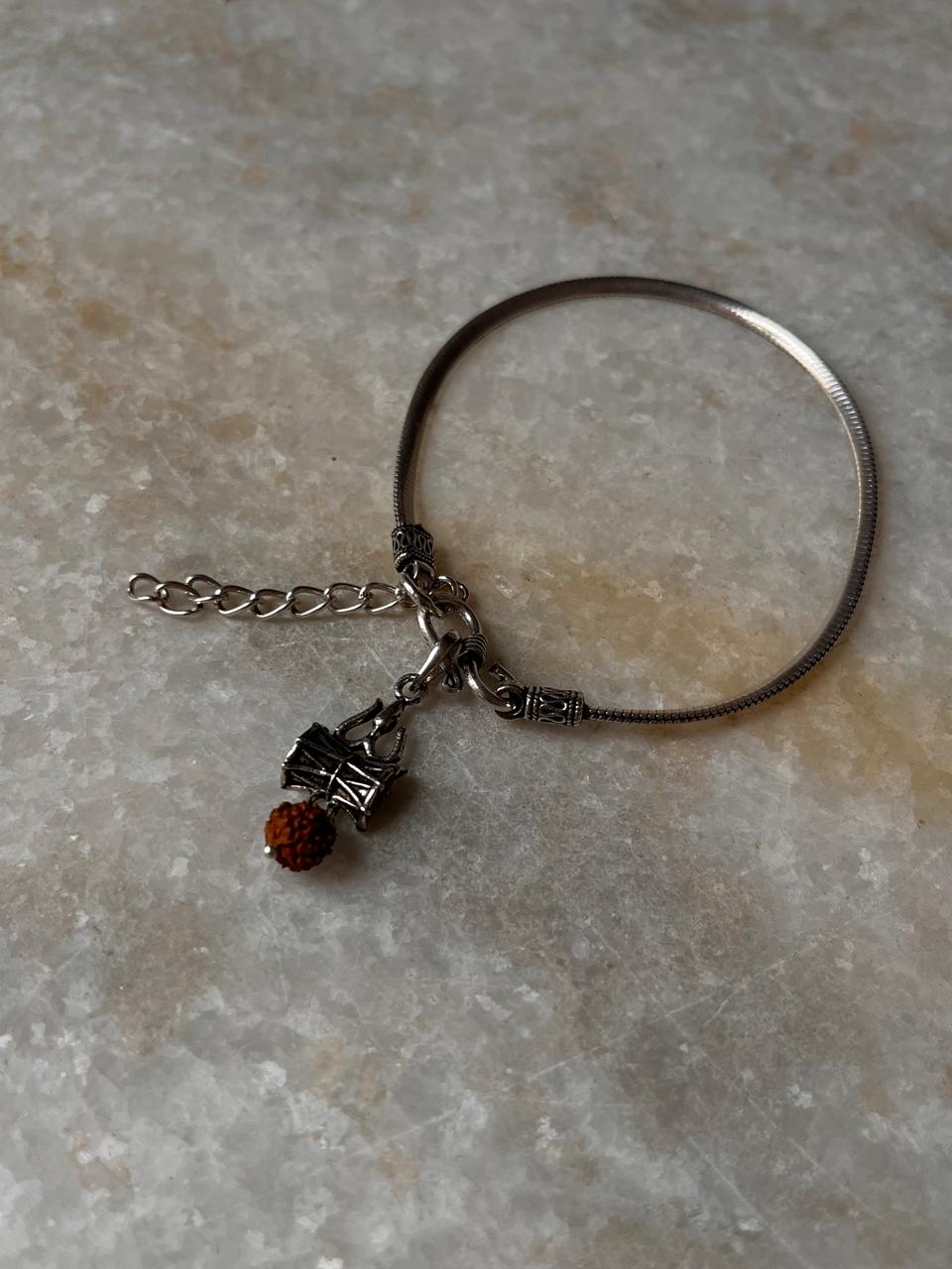 Flat Snake Antique and Trishul Damru Rudraksh 925 Sterling Silver Rakhi on marble background.