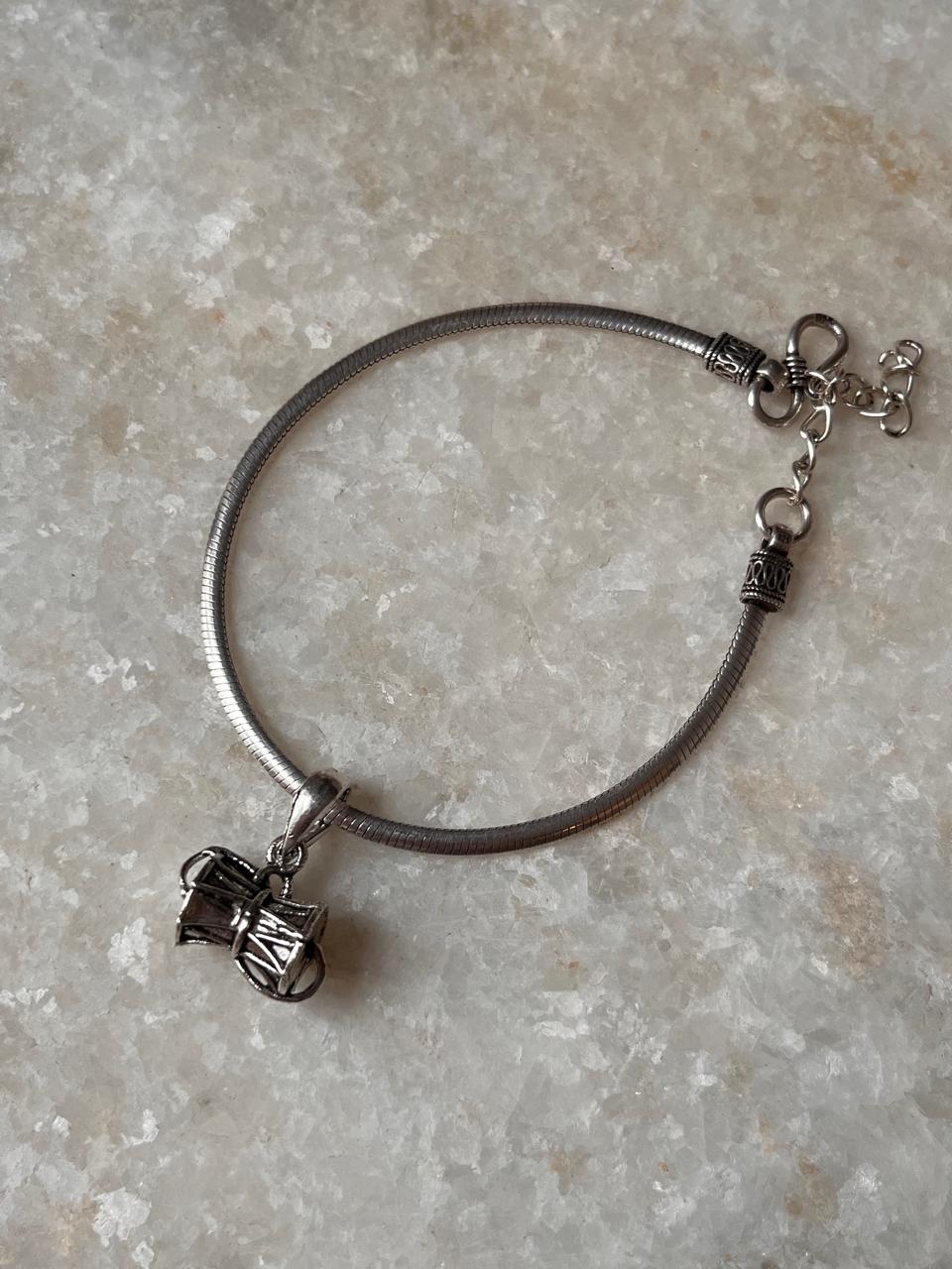 Elegant silver bracelet featuring a unique charm, perfect for adding a touch of style and tradition.
