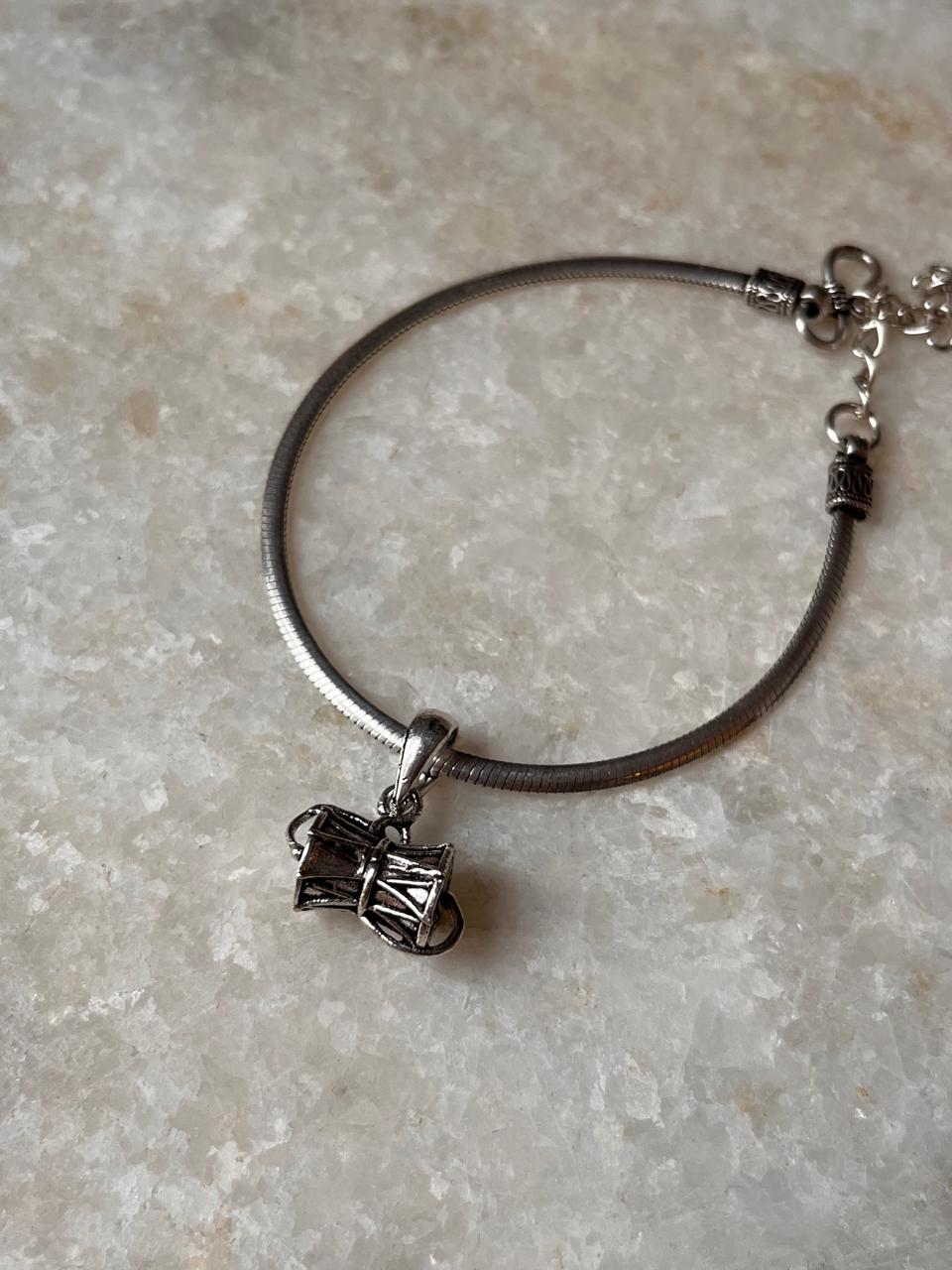 Flat Snake Antique & Medium Shiva Damru 925 Sterling Silver Rakhi with intricate design on a smooth background.