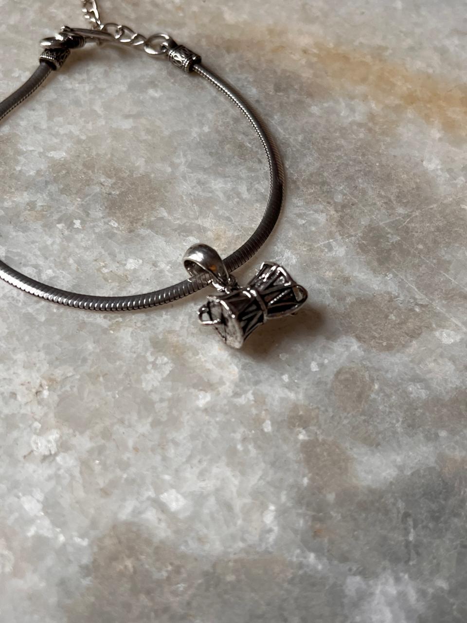 Antique-style 925 sterling silver rakhi featuring a detailed Shiva Damru charm on a sleek bracelet.