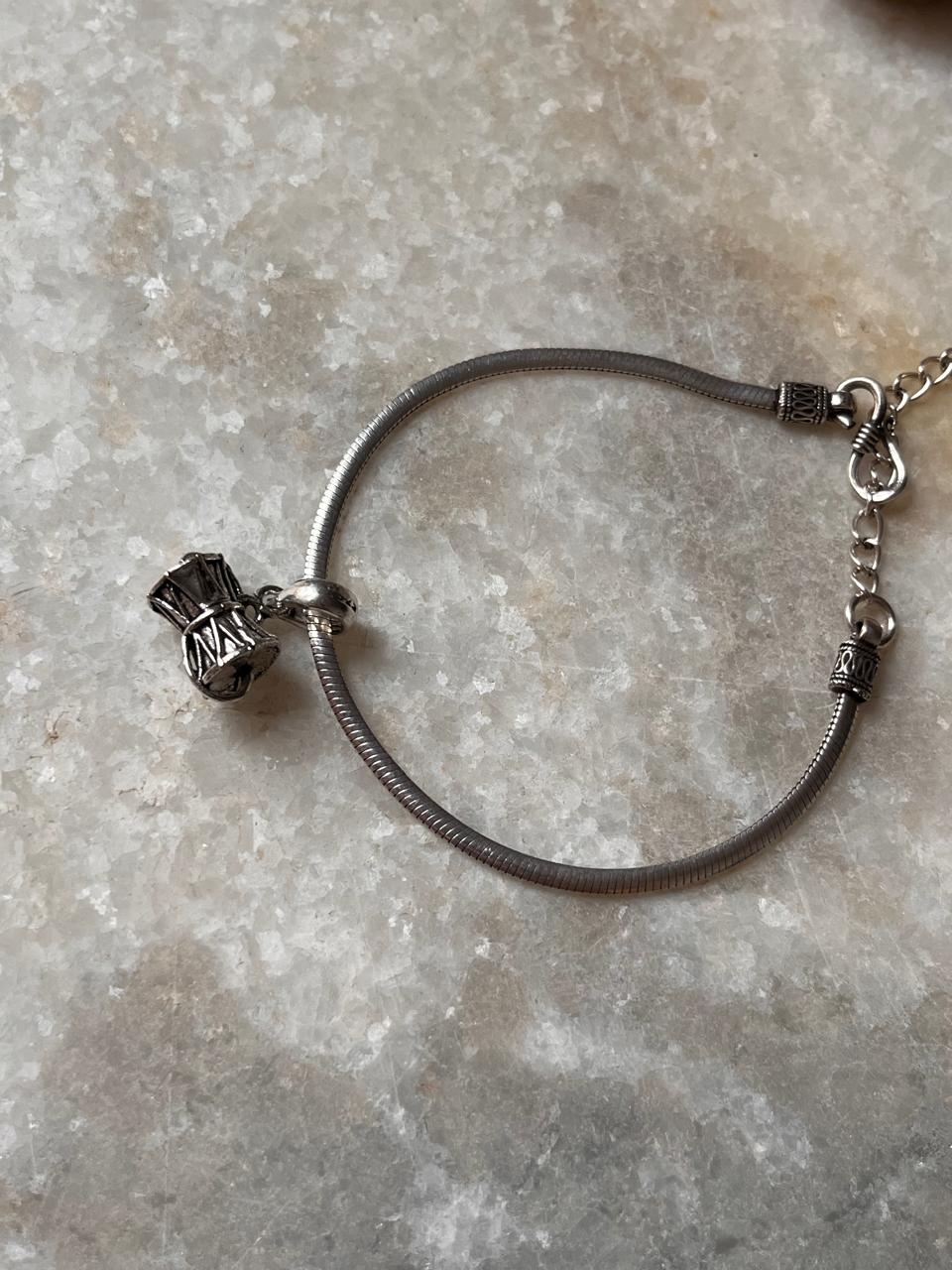 Elegant medium Shiva Damru design on a 925 sterling silver rakhi, symbolizing divine protection and strength.